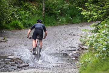 a mountain biker rides through the rivers.  A participant at The Raid of  The Hautes Fagnes in the...