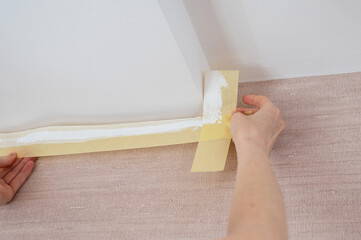 Close-up of female hands remove masking tape