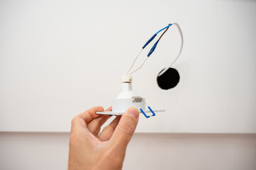 Hand inserts the lamp into the ceiling