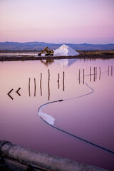 Salt farm excavator with sunset and a salt mountain