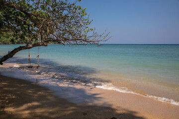 Beautiful old wooden swing on the beach. Sunny day. Colorful landscape. Beautiful sea.