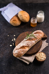 Fresh homemade artisan loaf of baguette breads on rustic background with copy space. sourdough mini baguette breads.