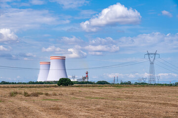 Fototapeta na wymiar energy power plant chimney and cooling towers. in cultivated fields.