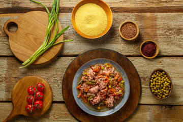 Israeli couscous with sumac and chicken stew pieces on the table in a plate next to the ingredients.