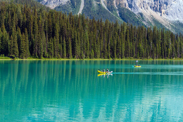 People kayaking on Emerald Lake inside Yoho national park, Canada.