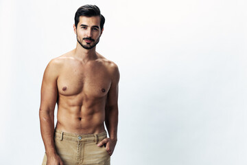 Male fashion model with a naked torso and abs packs sporty runs on a white isolated background,...