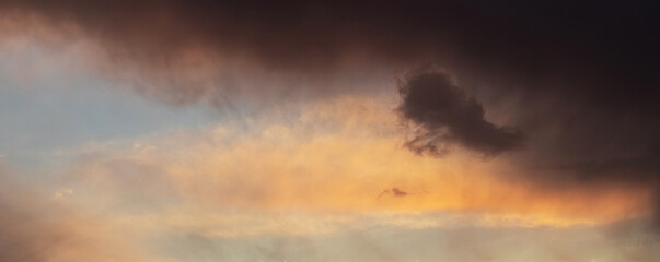 Naklejka na ściany i meble The sky with dark storm clouds at sunset