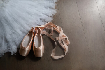 Ballet beige pointe shoes with a ribbon on the tutu skirt. Ballerina set. The concept of dance,...