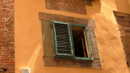 vecchia persiana verde a stecche di legno  con anta mancante in un palazzo antico, Lucca, Toscana, Italia