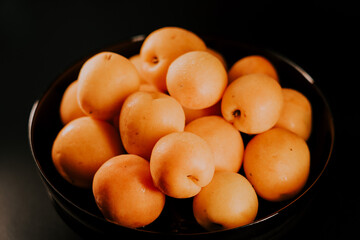 Ripe apricots on a black background