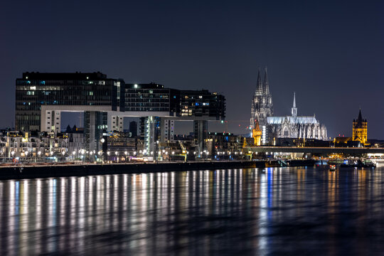 Köln bei Nacht - Kranhäuser und Dom mit Reflexionen im Rhein