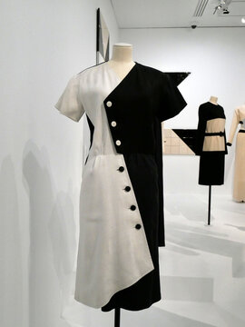 Yves Saint Laurent, french haute couture 1983, Paris, "shapes" : 
 black and white buttoned cocktail dress, geometric style set against a backdrop by Claudia Wieser