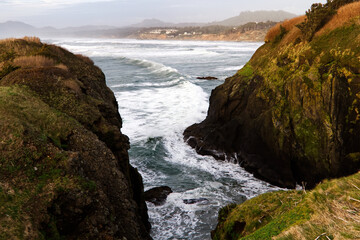 Fototapeta na wymiar Ocean Waves Surging Between Two Headland Cliffs