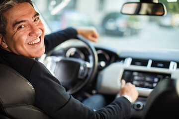 Middle aged latin man driving a car in the city