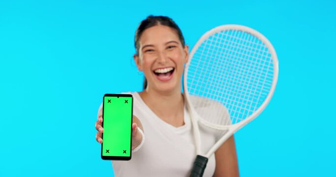 Phone, green screen and a woman tennis player on a blue background in studio for sports marketing. Portrait, smile and fitness with a female athlete holding chromakey mockup on a mobile screen