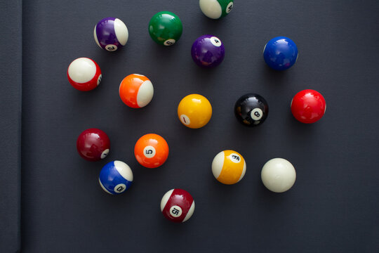 A top down view of a pool balls on a blue felt table.