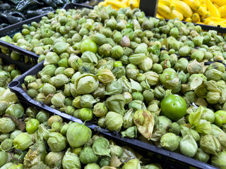 A view of a bin full of tomatillos, on display at a local grocery store.