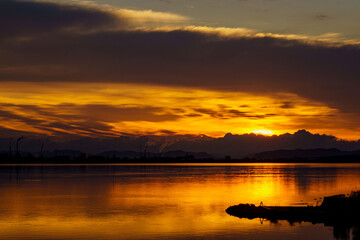 朝日で黄金色に光る湖