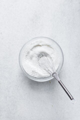 A bowl of white sugar, granulated sugar in an antique measuring spoon