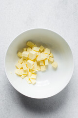 cubes of butter in a white bowl, organic butter in a white mixing bowl
