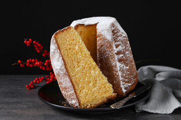 Delicious Pandoro cake with powdered sugar and decor on grey table. Traditional Italian pastry