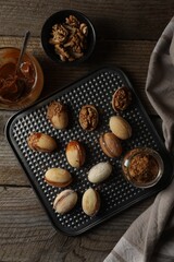 Freshly baked homemade walnut shaped cookies, boiled condensed milk and nuts on wooden table, flat lay