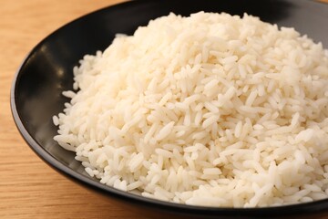 Plate with delicious rice on wooden table, closeup
