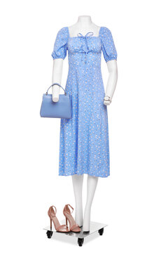 Female mannequin with accessories dressed in stylish light blue dress isolated on white