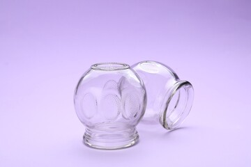 Glass cups on violet background. Cupping therapy
