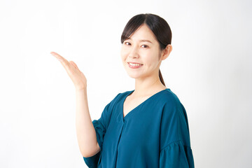 左側を手のひらで指すミドルエイジ女性　白背景