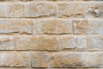 Rough textured wall surface made of huge blocks of natural stone. Background or backdrop. Design blank