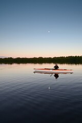 Woman kayaking on calm water in Coot Bay in Everglades National Park, Florida on calm clear afternoon..