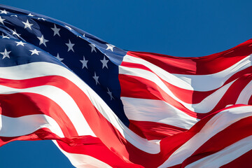 Closeup of giant American flag with blue sky waving