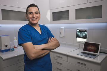 Portrait of latin dentist standing by dental equipment in clinic - obrazy, fototapety, plakaty