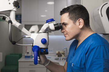 Latin dentist who is using the dental microscope in the clinic.