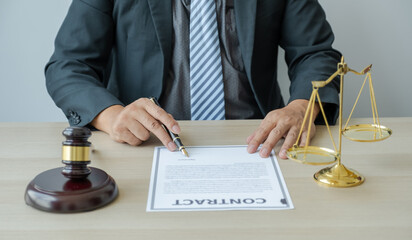 Lawyer hand holding pen and providing legal consult business dispute service at the office with justice scale and gavel hammer