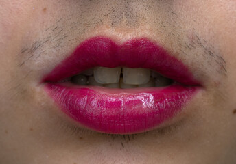 close up of a woman with a mustache wearing magenta lipstick, open mouth 