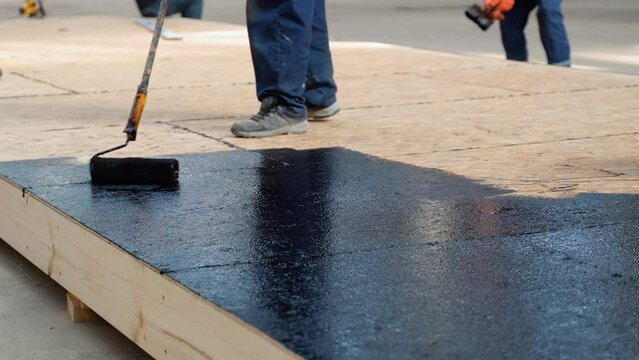 Waterproofing the floor in a private house, applying liquid resin to the floor, concrete screed and waterproofing, repair and construction work. . Modular prefabricated houses concept