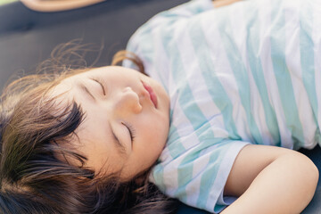 キャンプ場に来て遊び疲れて寝る子供
