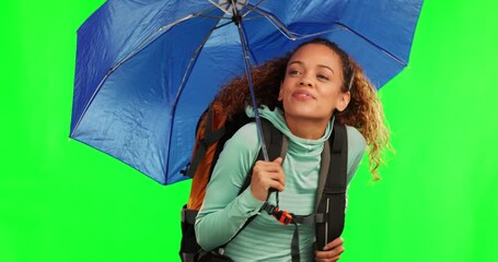 Young woman, umbrella and rain by green screen for travel, adventure and check sky with cover in mockup. Student girl, parasol and protection from winter weather with walking, journey and hiking