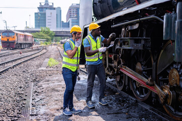 Engineer railway wearing safety gear checking train transmittal system for safety travel passenger