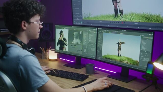 Young 3D designer draws video game character, creates animation. Teen trains 3D modeling and game development at home on computer and big digital screen with professional program interface for design.
