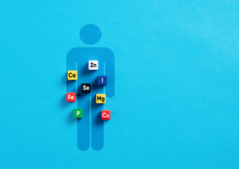 Essential minerals for body and health. Health care concept. Mineral symbols on colorful cubes over a human body symbol.