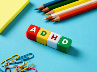 Attention deficit hyperactivity disorder ADHD concept. The abbreviation ADHD on colorful cubes with stationery objects - obrazy, fototapety, plakaty