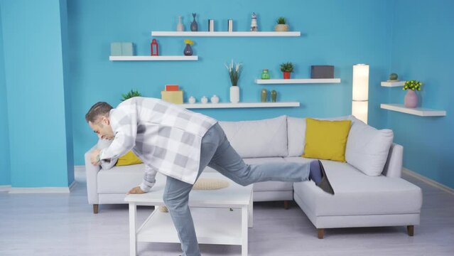 The clumsy man slams the table at home.