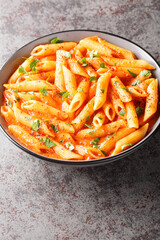 Pink Sauce Pasta most delicious penne with a cheesy tomato cream sauce closeup on the bowl on the table. Vertical