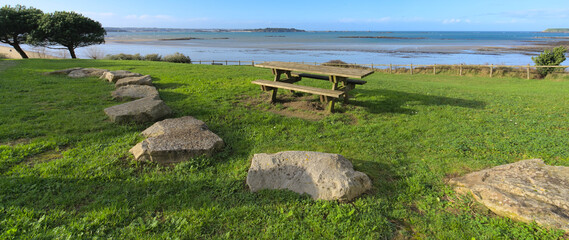 Fototapeta na wymiar View from park with brunch table of a sand beach during low tide a winter sunny afternoon, Lancieux, Brittany, north of France