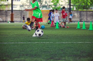 Obraz premium Soccer ball tactics children kick to control the ball on a grass field for the training