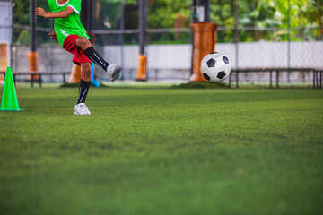 Soccer ball tactics children kick to control the ball on a grass field for the training