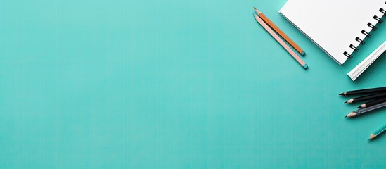 A notebook, pencils, and a pair of scissors on a turquoise background created with Generative AI technology